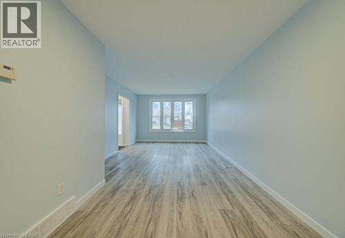 Empty room featuring light wood-style floors and baseboards - 310 Magnolia Drive, Hamilton, ON 