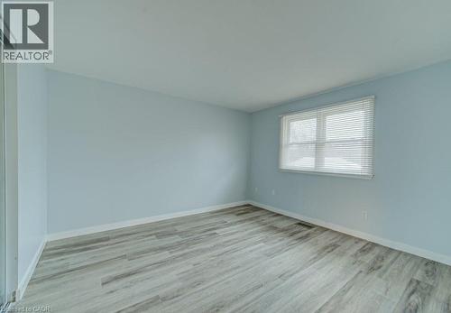 Unfurnished room with light wood-style floors and baseboards - 310 Magnolia Drive, Hamilton, ON 
