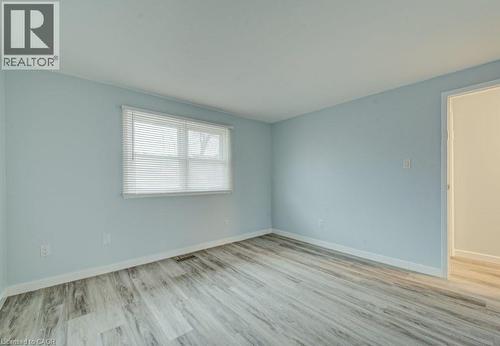 Unfurnished room with light wood-style flooring and baseboards - 310 Magnolia Drive, Hamilton, ON 