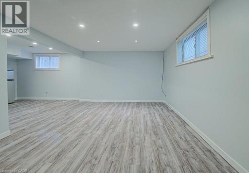 Basement with recessed lighting, light wood-style flooring, and freestanding refrigerator - 310 Magnolia Drive, Hamilton, ON 