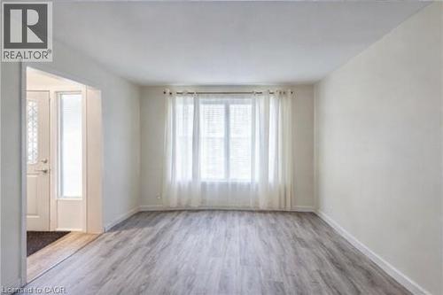 Unfurnished room featuring wood finished floors and baseboards - 310 Magnolia Drive, Hamilton, ON - Indoor Photo Showing Other Room