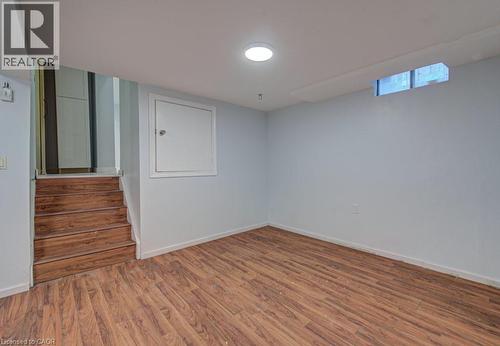Empty room with wood finished floors and stairway - 310 Magnolia Drive, Hamilton, ON 