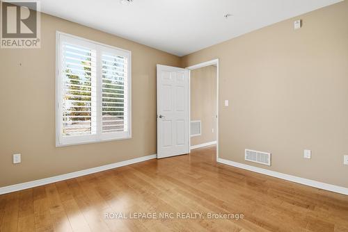 Primary Bedroom w/ hardwood & California Shutters - 203 - 16 Sullivan Avenue, Thorold (Thorold Downtown), ON - Indoor Photo Showing Other Room