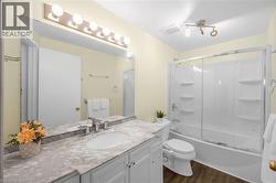 Full bath featuring vanity, bath / shower combo with glass door - 