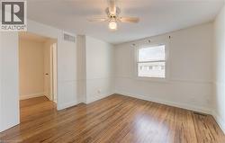 Empty room with light wood-style flooring and ceiling fan - 