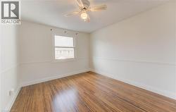 Unfurnished room with hardwood / wood-style flooring and a ceiling fan - 
