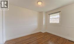 Spare room featuring wood-type flooring and a textured ceiling - 
