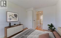 Bedroom featuring light wood-style floors and baseboards - 