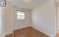 Unfurnished room featuring hardwood / wood-style floors and a textured ceiling - 