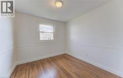 Unfurnished room featuring wood-type flooring and a textured ceiling - 