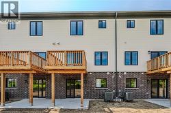 Back of property featuring a patio area and a wooden deck - 