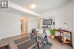 Workout room featuring light wood-style flooring and baseboards - 