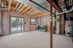 Below grade area with water heater, heating unit, and washing machine and dryer - 