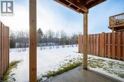 Yard covered in snow featuring a fenced backyard and a patio - 