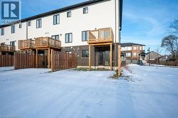 Snow covered rear of property with brick siding - 