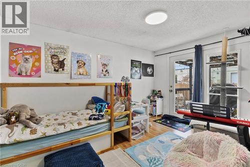 Bedroom featuring a textured ceiling, access to outside, and wood finished floors - 40 Bula Drive, St. Catharines, ON - Indoor