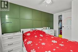 Bedroom with a decorative wall, a textured ceiling, a closet, and ceiling fan - 