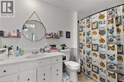 Full bathroom with curtained shower, vanity, and light tile patterned floors - 
