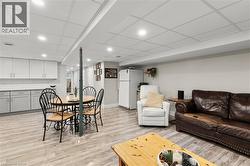 Living area with recessed lighting, a drop ceiling, and light wood-type flooring - 