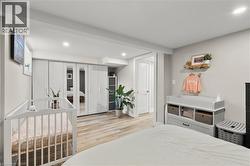 Bedroom featuring a crib, light wood finished floors, and recessed lighting - 