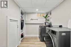 Laundry area featuring a drop ceiling, light wood-style floors, independent washer and dryer, and recessed lighting - 