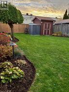 Fenced backyard featuring a storage shed - 
