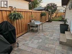 Fenced backyard with a patio and a grill - 