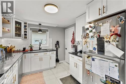 Kitchen featuring appliances with stainless steel finishes, white cabinets, glass insert cabinets, pendant lighting, and light marble finish flooring - 40 Bula Drive, St. Catharines, ON - Indoor Photo Showing Kitchen With Upgraded Kitchen
