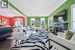 Living area featuring ornamental molding, a high end fireplace, a chandelier, and wood finished floors - 