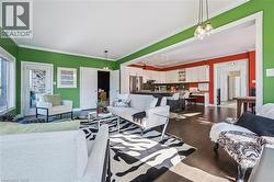 Living area with ornamental molding, dark wood-style floors, and a chandelier - 