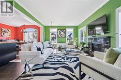 Living area featuring crown molding, a high end fireplace, wood finished floors, and a chandelier - 