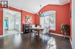 Dining area with lofted ceiling, ornamental molding, a chandelier, plenty of natural light, and dark wood-style floors - 