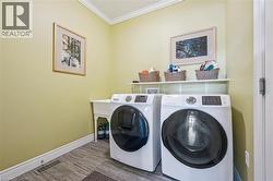 Laundry area featuring crown molding and washer and clothes dryer - 