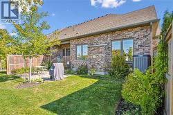 Rear view of house with a patio area, brick siding, and roof with shingles - 