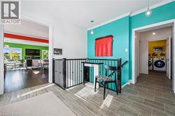 Hall featuring crown molding, washing machine and dryer, an upstairs landing, and wood tiled floors - 