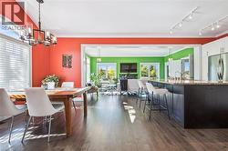 Dining room featuring a chandelier, track lighting, dark wood-style flooring, and crown molding - 