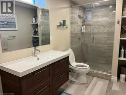 Bathroom with vanity, light wood-style flooring, and a stall shower - 
