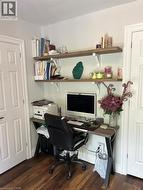 Office space featuring dark wood finished floors and baseboards - 