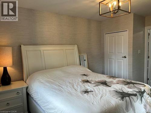 Bedroom featuring a closet, wallpapered walls, and a chandelier - 235 Fearnwood Street, Cambridge, ON - Indoor Photo Showing Bedroom