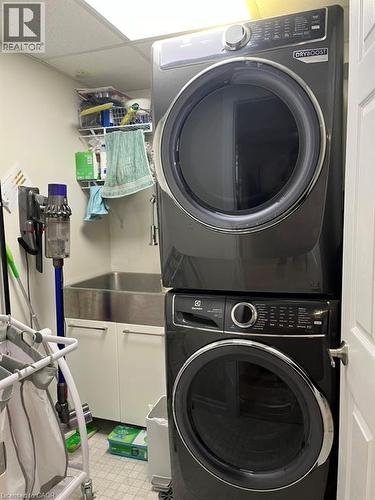 Laundry area featuring stacked washer / drying machine, a drop ceiling, and light floors - 235 Fearnwood Street, Cambridge, ON - Indoor Photo Showing Laundry Room