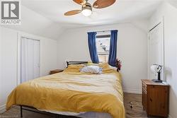 Bedroom with a closet, ceiling fan, lofted ceiling, and wood finished floors - 