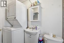 Half bath featuring vanity and stacked washing machine and dryer - 