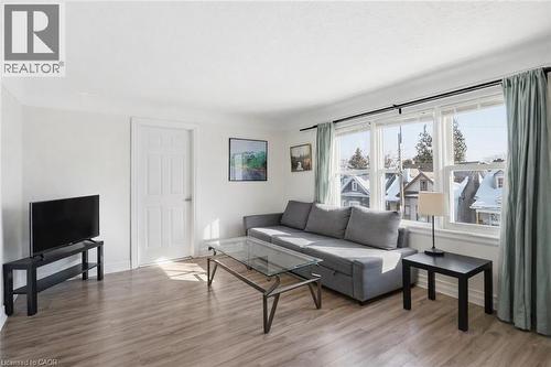 Living room with light wood-style flooring and baseboards - 260 Prospect Street S, Hamilton, ON - Indoor Photo Showing Living Room