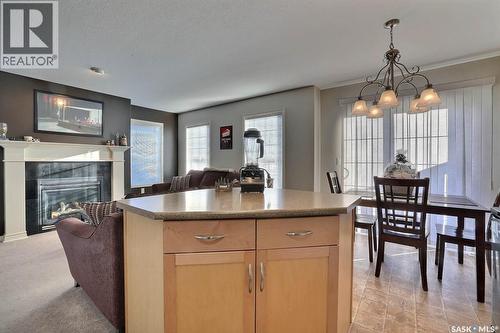 15 3101 Tregarva Drive E, Regina, SK - Indoor Photo Showing Dining Room With Fireplace