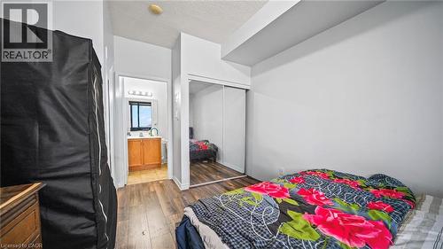 Bedroom with dark wood-style floors, a textured ceiling, and a closet - 388 Prince Of Wales Drive Unit# 1609, Mississauga, ON - Indoor Photo Showing Bedroom