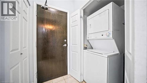 Laundry room with estacked washer and dryer and light tile patterned floors - 388 Prince Of Wales Drive Unit# 1609, Mississauga, ON - Indoor Photo Showing Laundry Room
