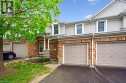 View of property featuring driveway and brick siding - 