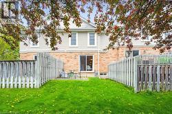 Rear view of house featuring brick siding and a fenced backyard - 