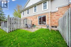 Back of property featuring brick siding, entry steps, and a patio area - 