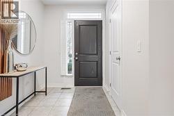 Foyer entrance featuring baseboards and light tile patterned floors - 